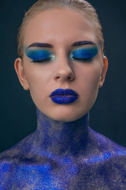 Portrait of a girl strewn with blue sequins with bright make-up - Photo, image