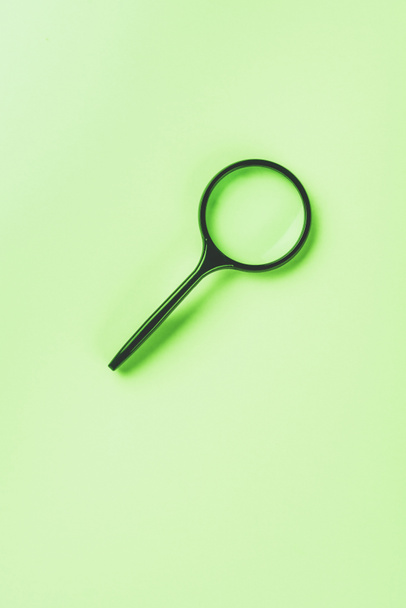 closeup shot of magnifying glass on green background  - Foto, imagen
