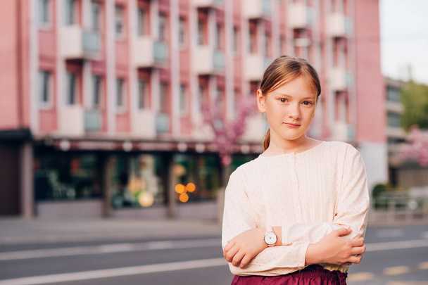Portrait de rue de mignonne petite fille en chemisier beige et montre rose, mode pour enfants
 - Photo, image