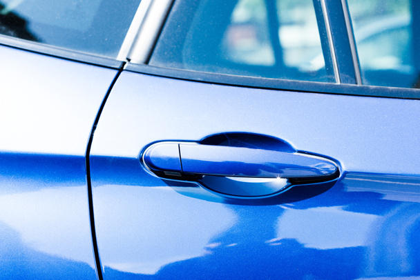 Προβολή με μεγέθυνση της λαβής σε μπλε αυτοκίνητο πόρτα  - Φωτογραφία, εικόνα