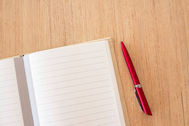 Escritorio de oficina: página del cuaderno en blanco y lápiz rojo en tabl de oficina de madera
 - Foto, imagen