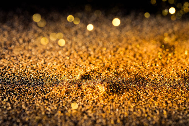Sprinkle gold shiny dust on a black background with copy space - Foto, Imagem