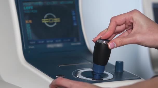 Közeli kép: display auto refraktométer és keze látszerész vizsgálata során - Felvétel, videó