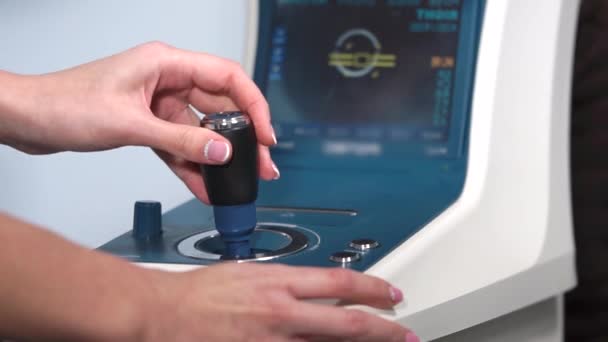 close up tiro das mãos médicos ele controla joystick de autorefratômetro
 - Filmagem, Vídeo