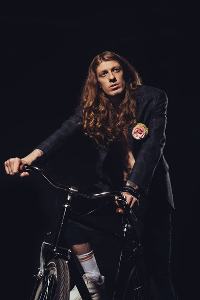 modieuze knappe man poseren met fiets, geïsoleerd op zwart - Foto, afbeelding