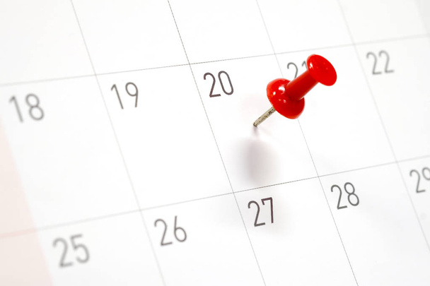 Geborduurde rode pinnen op een kalender op de 20e met selectieve aandacht - Foto, afbeelding