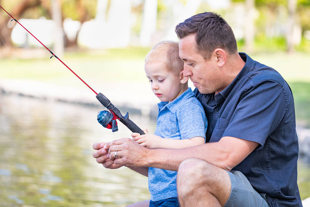 Nuori valkoihoinen isä ja poika ottaa hauskaa kalastusta järvellä - Valokuva, kuva