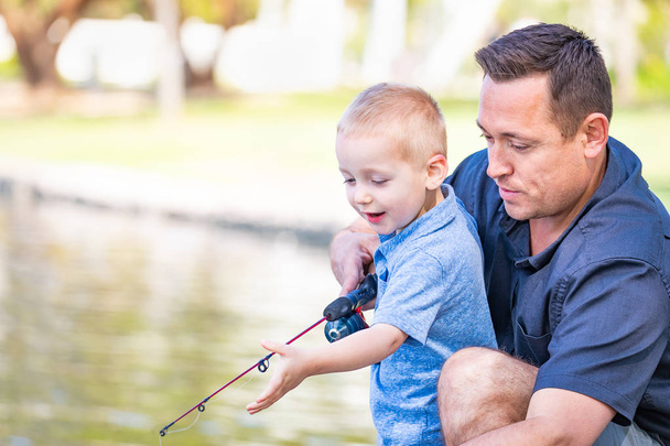 Jeune père et fils caucasiens s'amuser à la pêche au lac - Photo, image