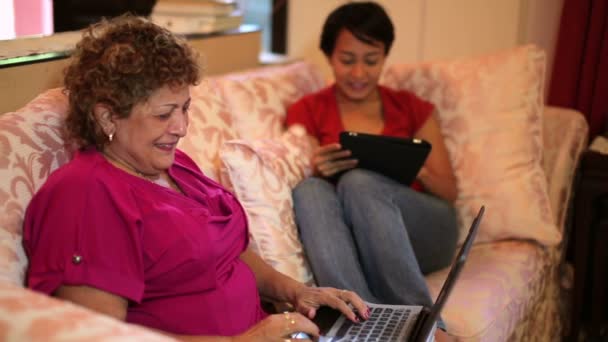 Madre e hija usando tableta juntos en casa
 - Metraje, vídeo
