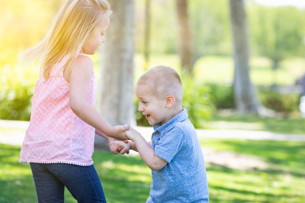 Молодой брат и сестра играют в парке Тогтер
 - Фото, изображение