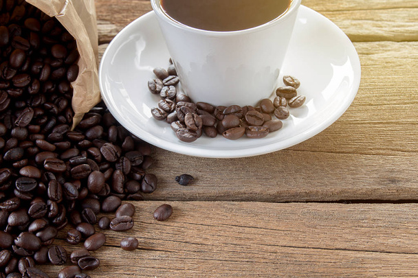 ホット コーヒーとコーヒー豆の木のテーブルの背景に - 写真・画像