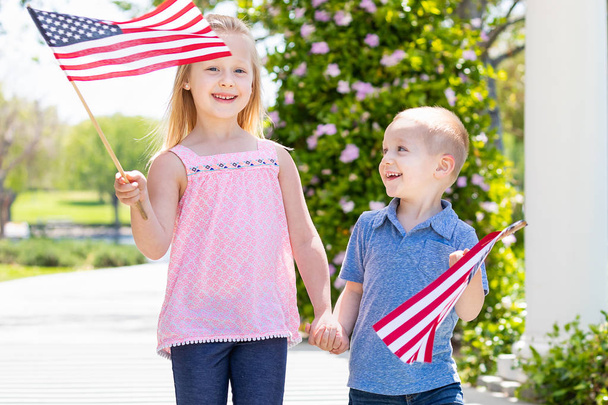 Młoda siostra i brat macha flagi amerykańskiej w parku - Zdjęcie, obraz