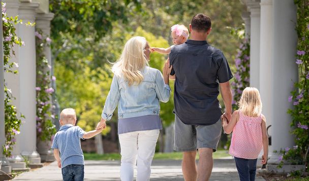 Nuori valkoihoinen perhe kävelyllä puistossa
 - Valokuva, kuva