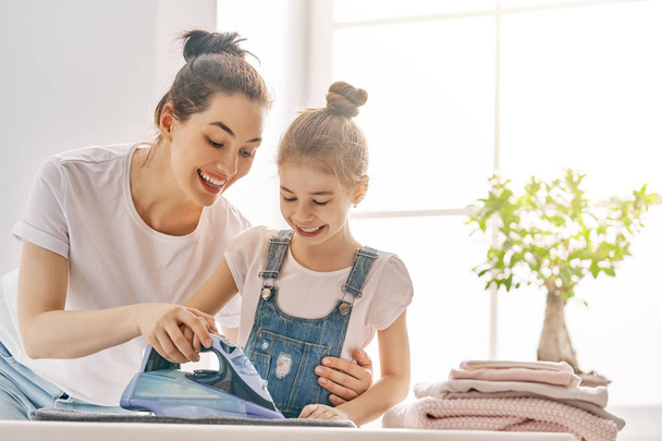 mother and daughter ironing at home - Foto, imagen