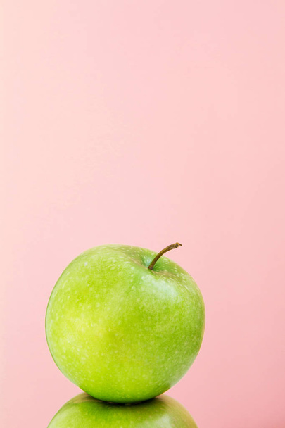 onderdeel van groene appel op roze achtergrond - Foto, afbeelding