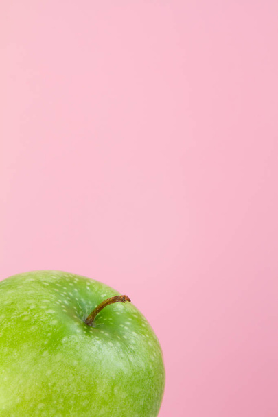 part of green Apple on pink background - Фото, изображение
