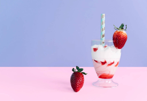 Milkshake with straw and strawberry. - Фото, зображення