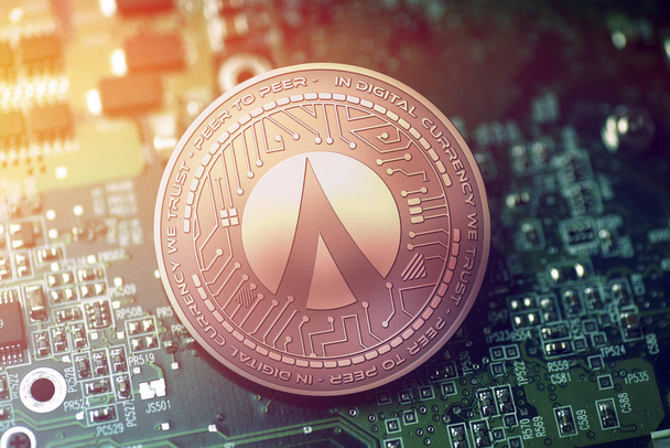 shiny copper DENTACOIN cryptocurrency coin on blurry motherboard background - Photo, Image