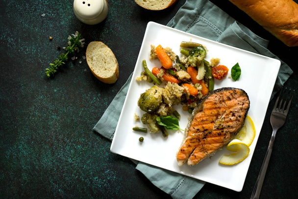 Grilled salmon steak, couscous and vegetables on stone or concre - Photo, Image