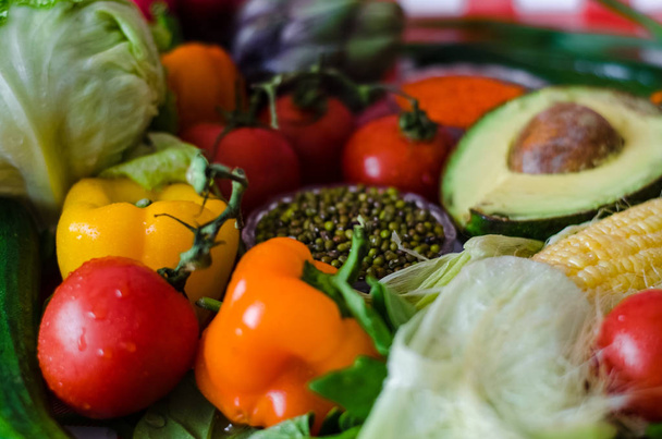 Voedzaam voedsel, niet-scherpsmakende pepers, stuk van groene kool in de linker boven hoek en schattige artisjok verschuilt zich achter - Foto, afbeelding
