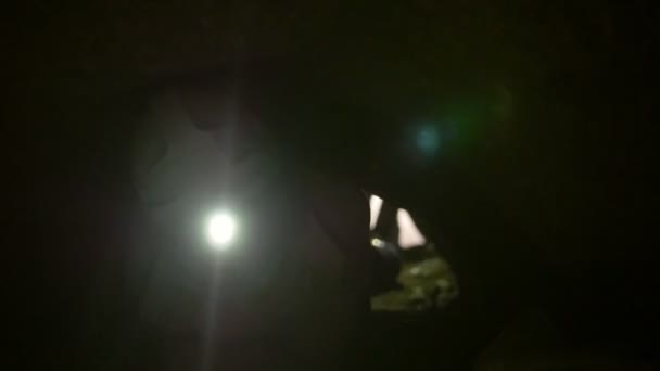 Jovens exploradores em capacetes com lanternas embaralha em todas as quatro na caverna escura
 - Filmagem, Vídeo