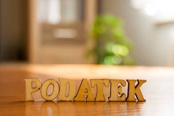 La palabra polaca tax 'podatek' hecha de letras de madera. inscripción de madera en la mesa
 - Foto, imagen