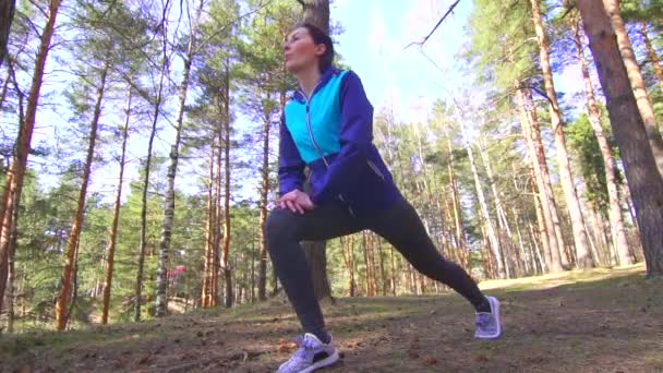 Sportmädchen Brünette Stretching in einem sonnigen Wald, slow mo - Filmmaterial, Video