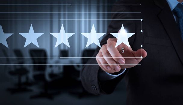 Пять звезд (5) рейтинга с бизнесменом - это трогательный экран виртуального компьютера.
. - Фото, изображение