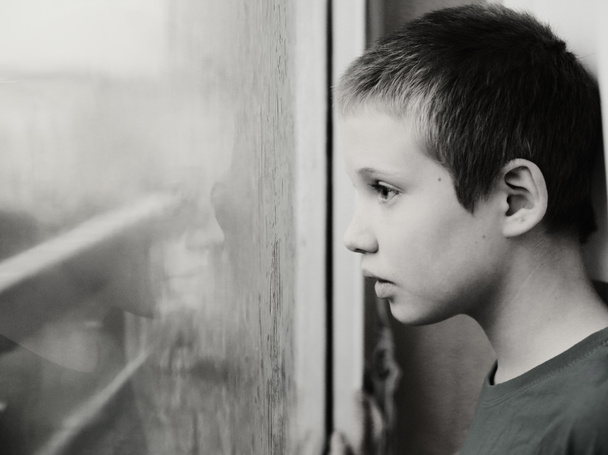 cute ten years old autistic boy looking at rain, black and white  - Foto, imagen