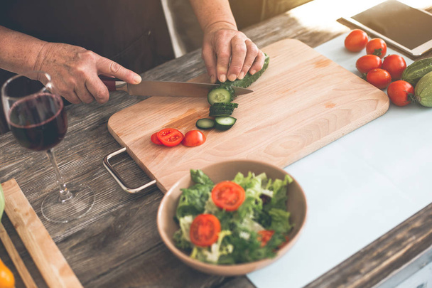 Senior lady arms chopping vegetables for dinner - Foto, imagen