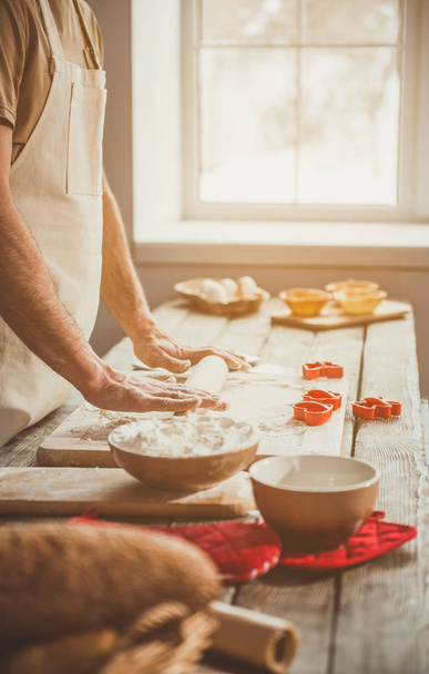 Male person using rolling pin for dough - Photo, image