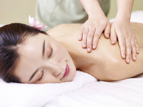 jonge Aziatische vrouw ontvangen van massage in de spa salon - Foto, afbeelding