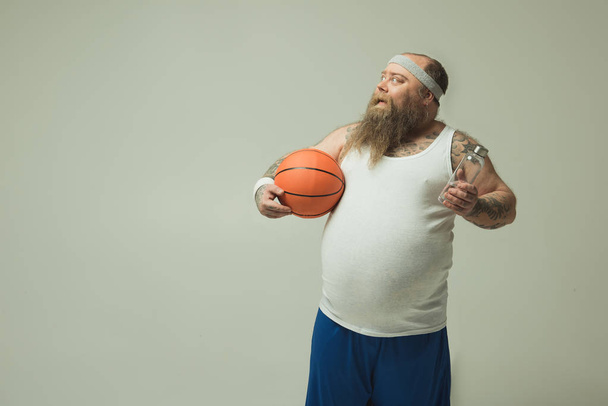 Cheerful fat guy resting after playing basketball - Foto, Imagem