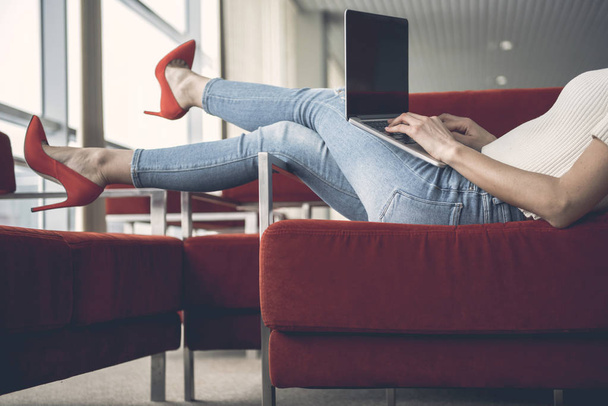 Girl tying in laptop on sofa - Foto, imagen