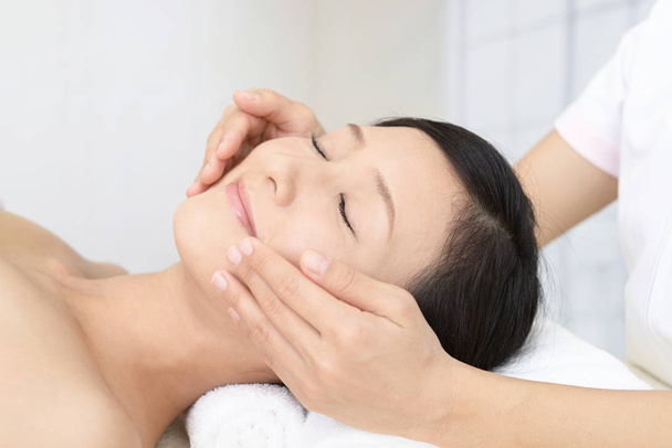 Beautiful young woman receiving facial massage - Photo, Image