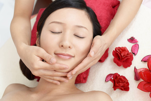 Hermosa joven recibiendo masaje facial - Foto, imagen