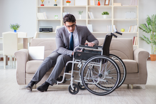 Dsabled businessman on wheelchair working home - Foto, afbeelding
