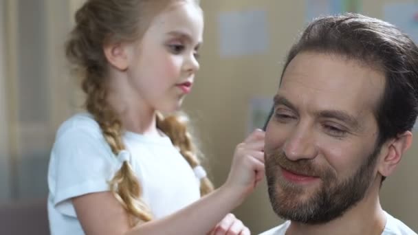 Caring daughter combing father hair and kissing cheek, family love, parenthood - Video