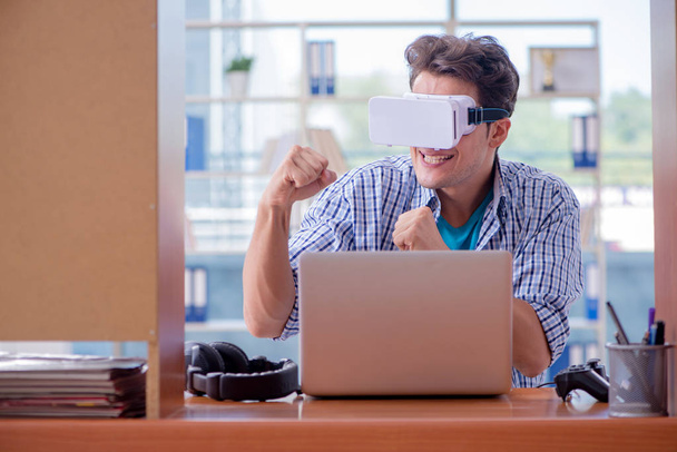 Νεαρός που παίζει ηλεκτρονικό παιχνίδι με γυαλιά εικονικής πραγματικότητας - Φωτογραφία, εικόνα