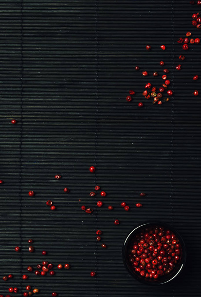 Pink pepper, rose, black mat, top view - Φωτογραφία, εικόνα