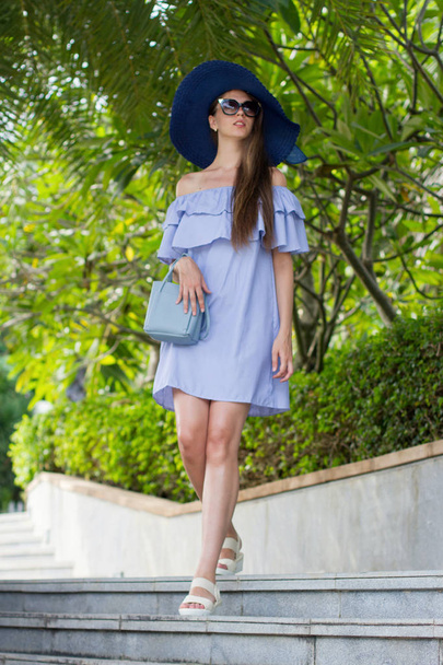 Mädchen in voller Länge in einem Kleid und Hut Mädchen in blauem Kleid mit Handtasche go street - Foto, Bild