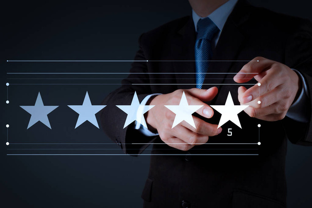 Five stars (5) rating with a businessman is touching virtual computer screen.For positive customer feedback and review with excellent performance. - Photo, Image