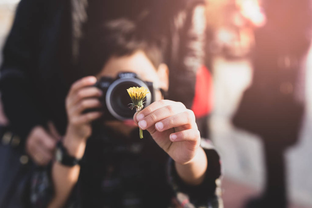 Young boy with mother taking photos of yellow flower in Cinemati - Zdjęcie, obraz