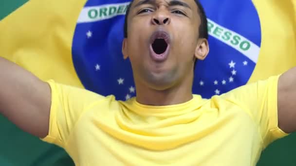 Brasilianischer Fan feiert das Halten der brasilianischen Fahne in Zeitlupe - Filmmaterial, Video