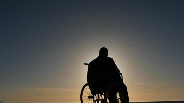 ανάπηρο άνθρωπο σε αναπηρικό αμαξίδιο αργή κίνηση σιλουέτα - Πλάνα, βίντεο