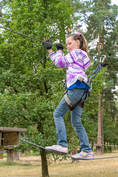 Girl in adventure climbing high wire park - Foto, imagen
