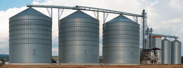 Silos. Storage and drying of grains, wheat, corn, soy, sunflower against the blue sky. Panorama. - Photo, Image