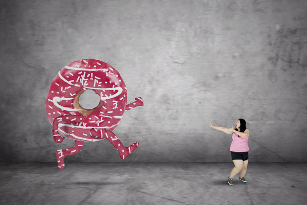Obézní žena utíká kobliha - Fotografie, Obrázek