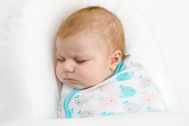 眠っているかわいい新生児女の子が毛布に包まれて - 写真・画像