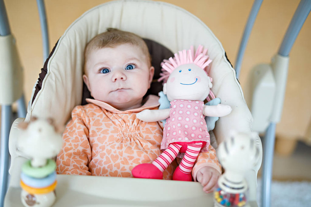 мила чарівна новонароджена дитина сидить в гойдалках
 - Фото, зображення